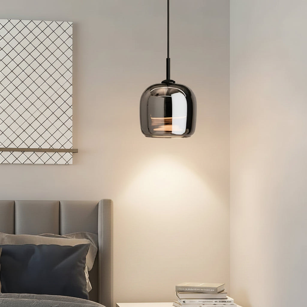 Smoked glass cube pendant light hanging over dining area, black cord