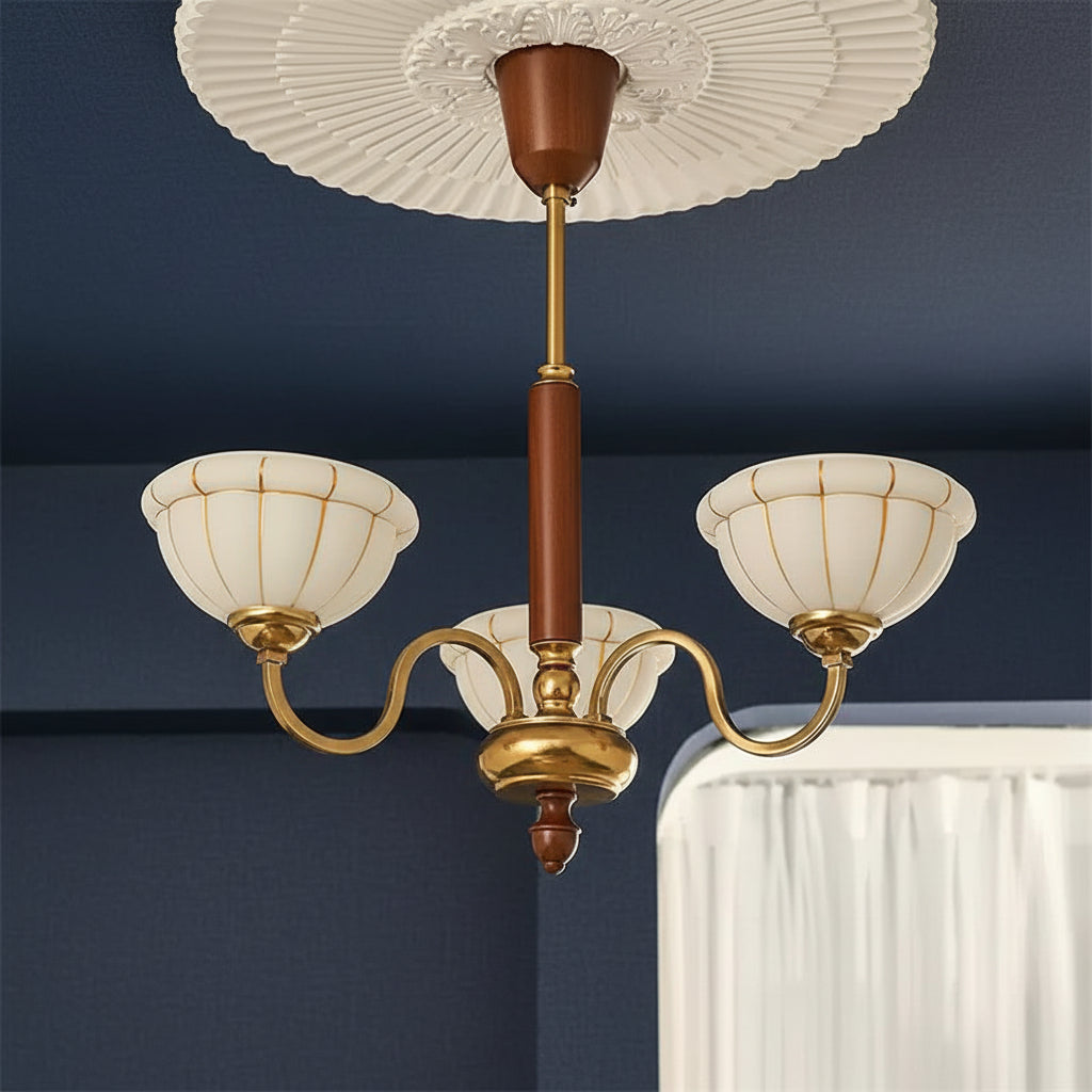 Gold 5-light chandelier with curved arms, off-white glass shades, brown top cap
