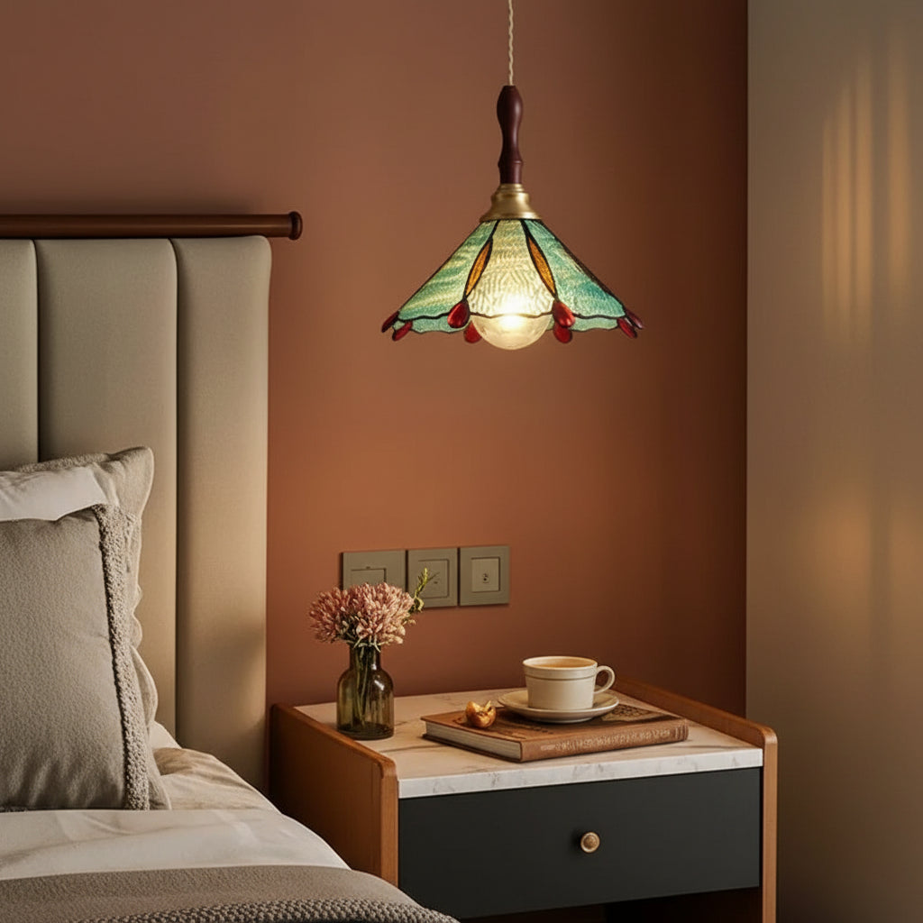 Scalloped stained-glass pendant light with green shade, brass top, and hanging cord