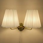Double-head fabric wall lamp: two pleated cream shades, gold mount, corded plug