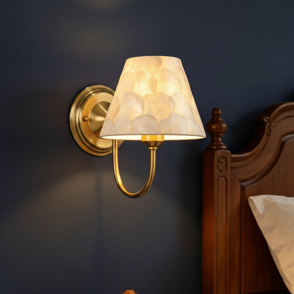 Gold conical capiz shell wall sconce with curved arm and round wall mount base