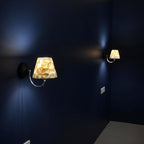 Gold conical capiz shell wall sconce with illuminated shade and curved metal arm
