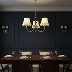 Gold multi-arm chandelier with cream scalloped shades and central hanging chain
