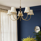Gold chandelier with cream scalloped lampshades and bead chain detail