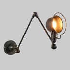 Black swing arm wall light with dome shade and metal ring frame, lit
