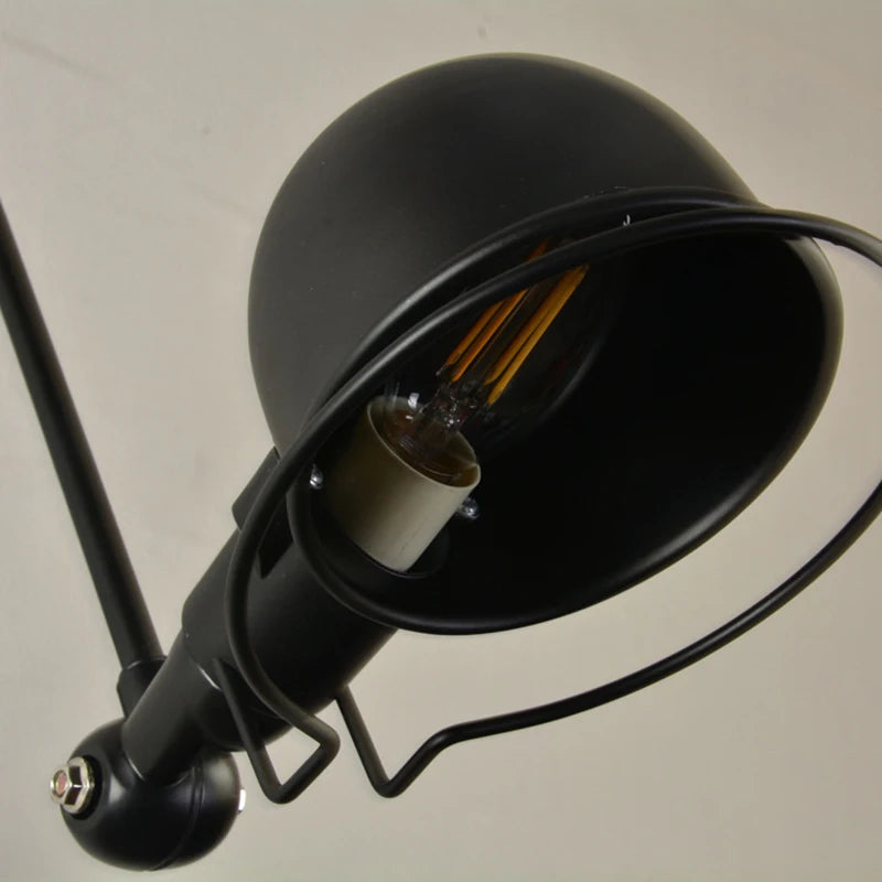 Close-up of black dome shade swing arm wall light with exposed bulb