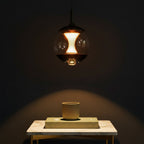 Hourglass globe pendant light with clear glass shade and warm amber mesh core