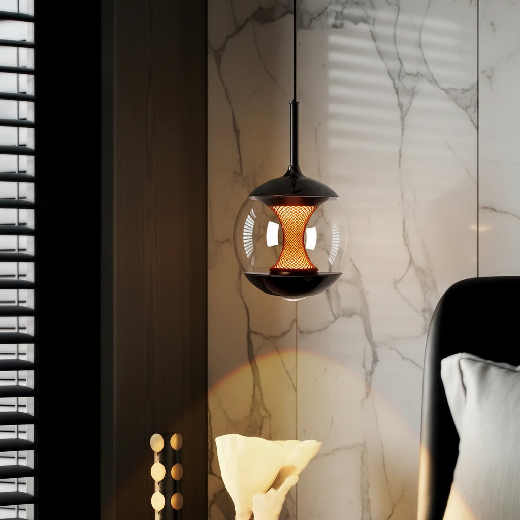 Hourglass globe pendant light with black top and clear glass housing over warm amber glow