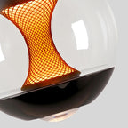 Hourglass globe pendant light detail showing warm amber grid mesh inside clear glass