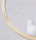 Wood halo bird wall light detail with white bird figure inside pale ring