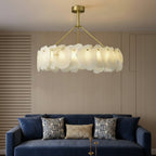 Brass tiered chandelier with glowing white scalloped drum disc shades