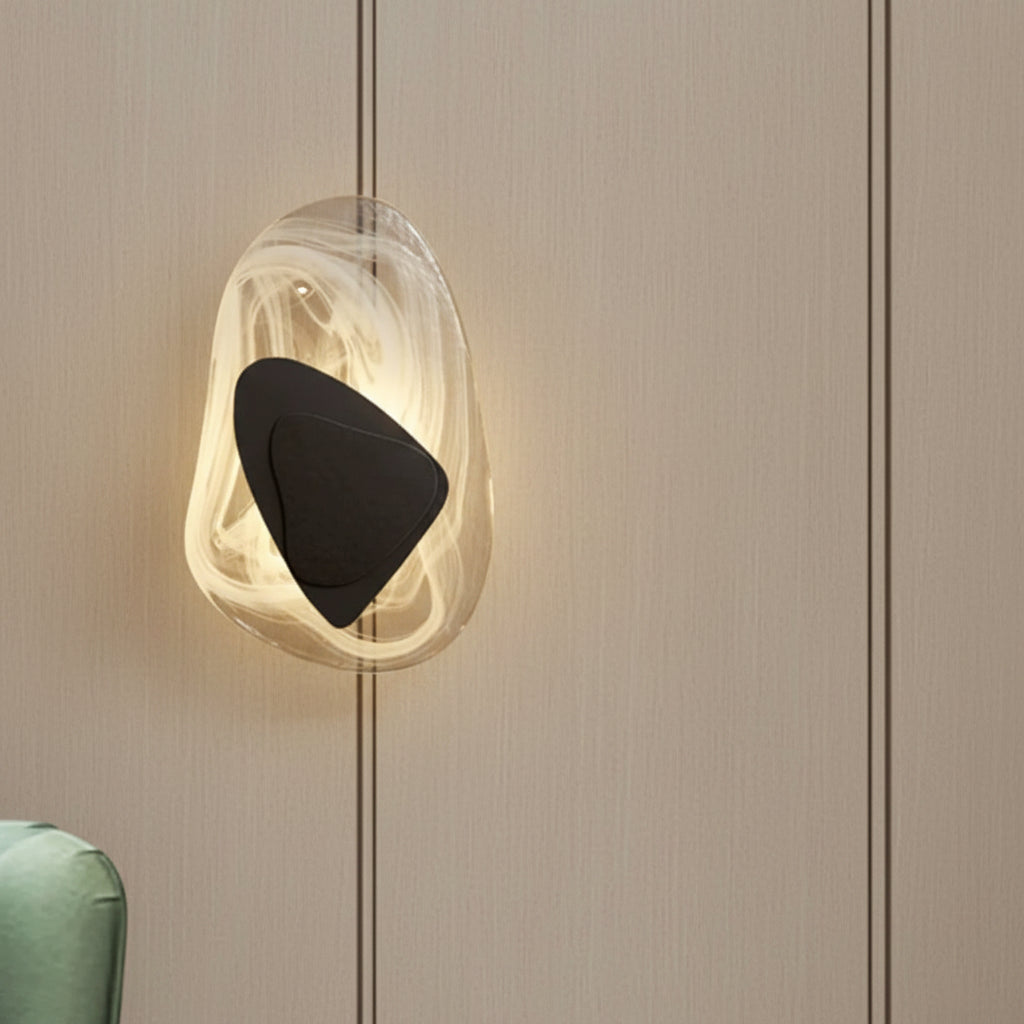 Layered egg wall light with translucent oval shell and black inner shade, warm illumination.
