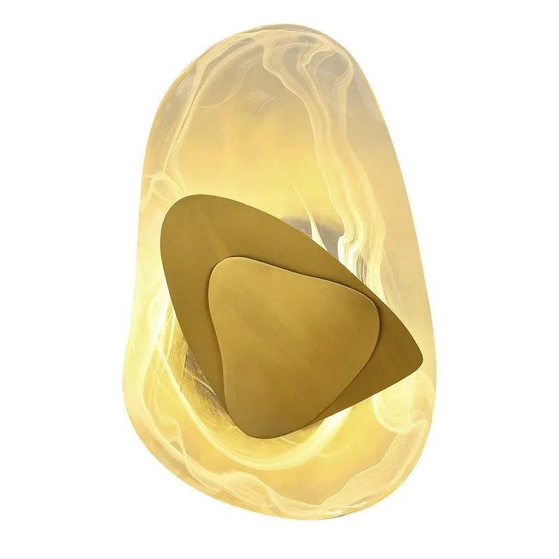 Layered egg wall light close-up: translucent shell with gold inner plate, warm light.