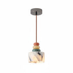 Pendant light with round ceiling canopy, marble-look shade, and stacked pebble beads