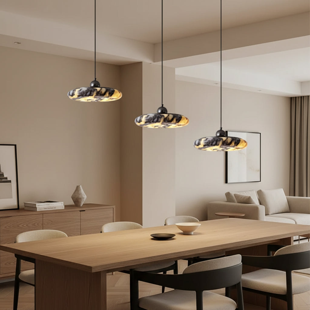 Marble round pendant lights set with gray-amber veined discs and black hanging cords