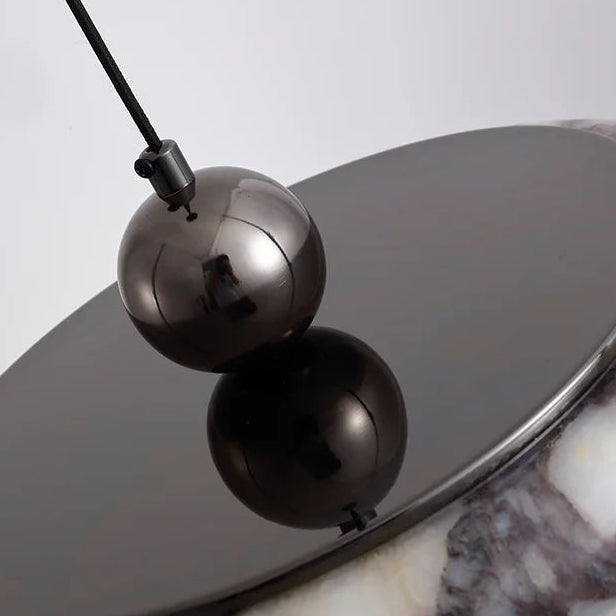 Pendant light shade assembly with black spherical housing and gray disc backing