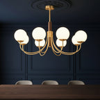 Gold and dark brown chandelier with several round glass globe bulbs on curved metal arms