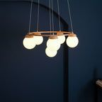 Modern globe chandelier with round wooden top ring, frosted glass spheres, and vertical cords