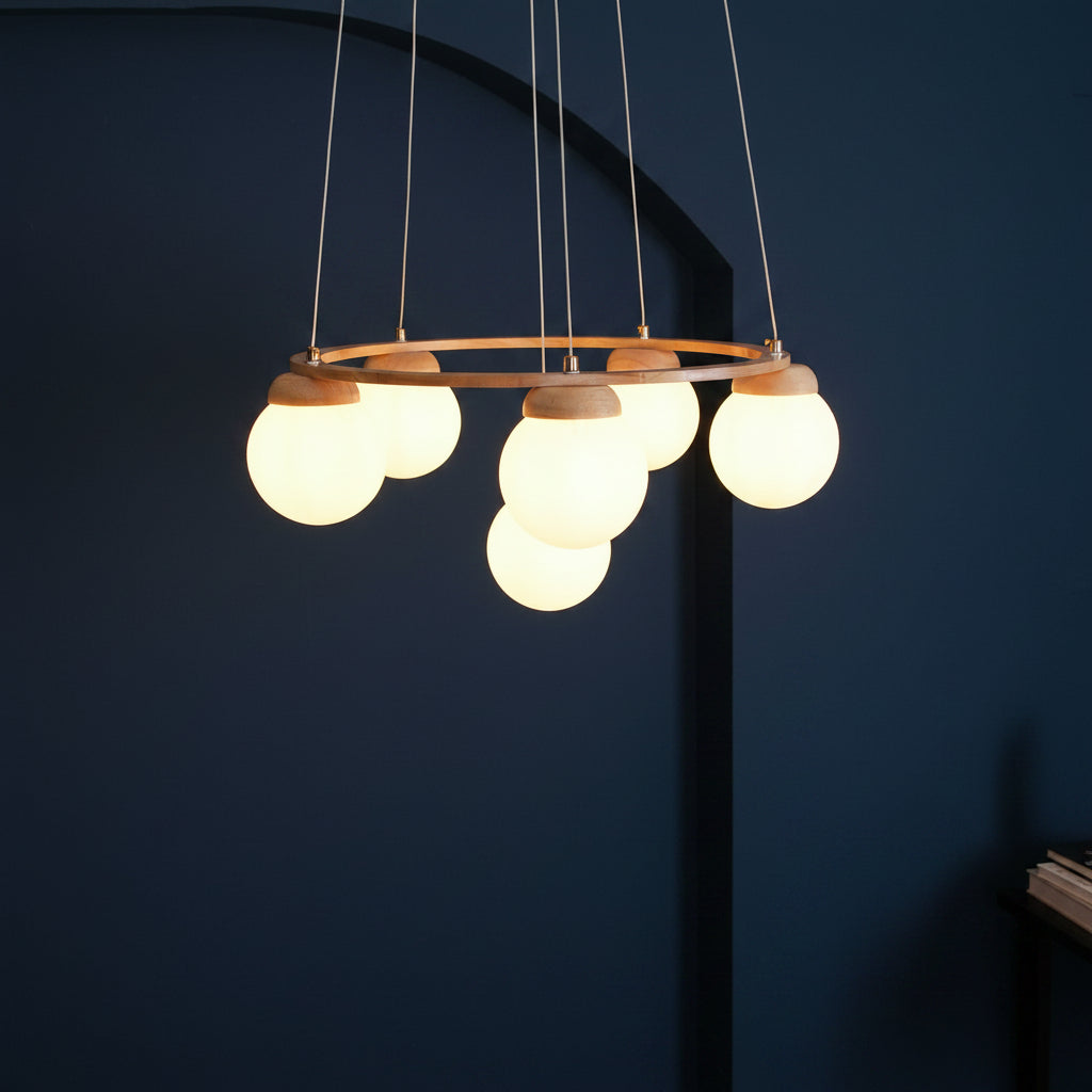Modern globe chandelier with round wooden top ring, frosted glass spheres, and vertical cords