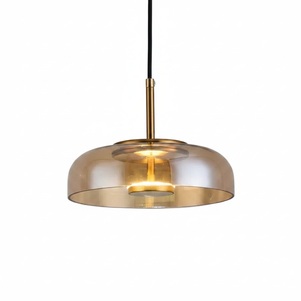 Amber-tinted glass dome pendant light with brass top ring and warm glowing bulb