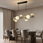 Globe chandelier with textured glass balls on black bar and two hanging rods