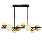 Globe chandelier with textured glass spheres, black canopy, and brass frame
