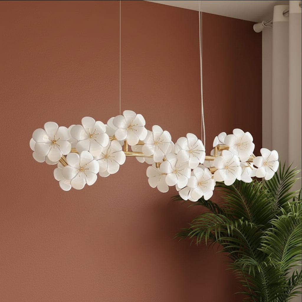 Flower-shaped white chandelier shades on a gold linear bar with hanging stems