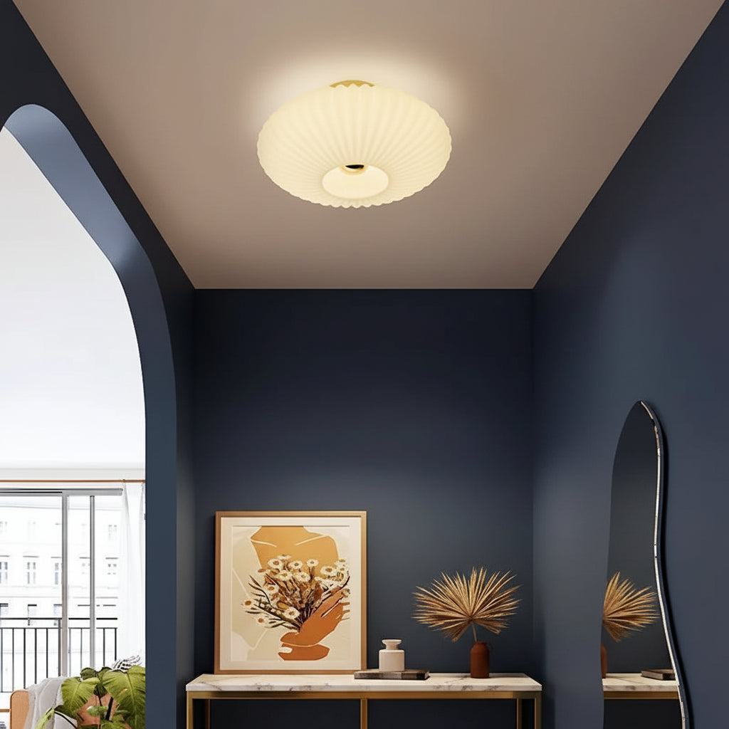 White fluted saucer ceiling light with a ribbed diffuser and round recessed center