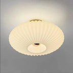 White fluted saucer ceiling light close-up with ribbed diffuser and central round opening