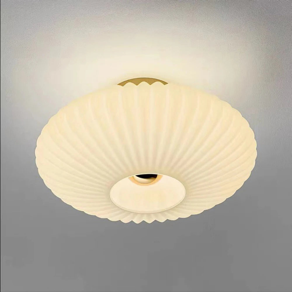White fluted saucer ceiling light close-up with ribbed diffuser and central round opening