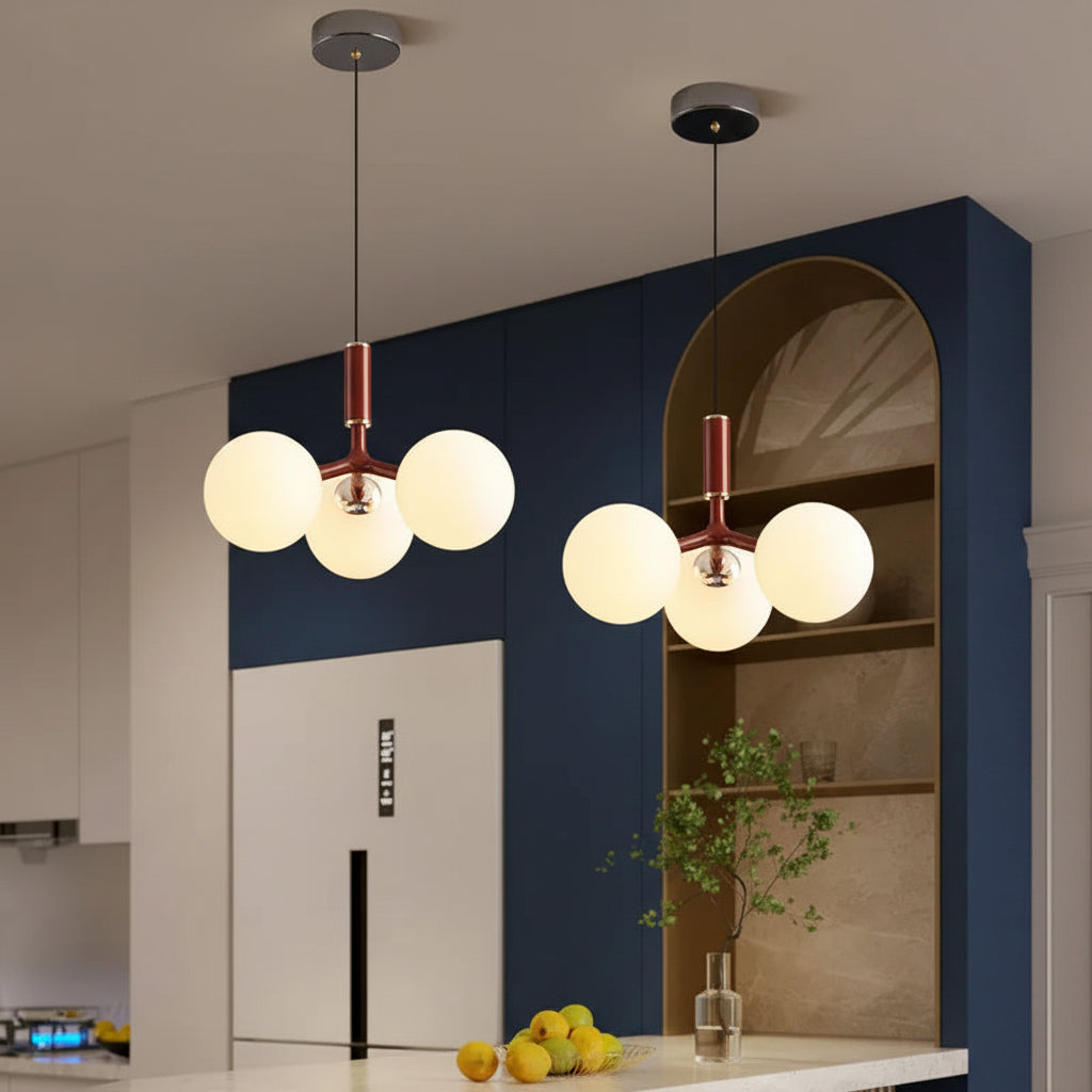 Globe pendant light with three white glass spheres, black canopy, and copper stem