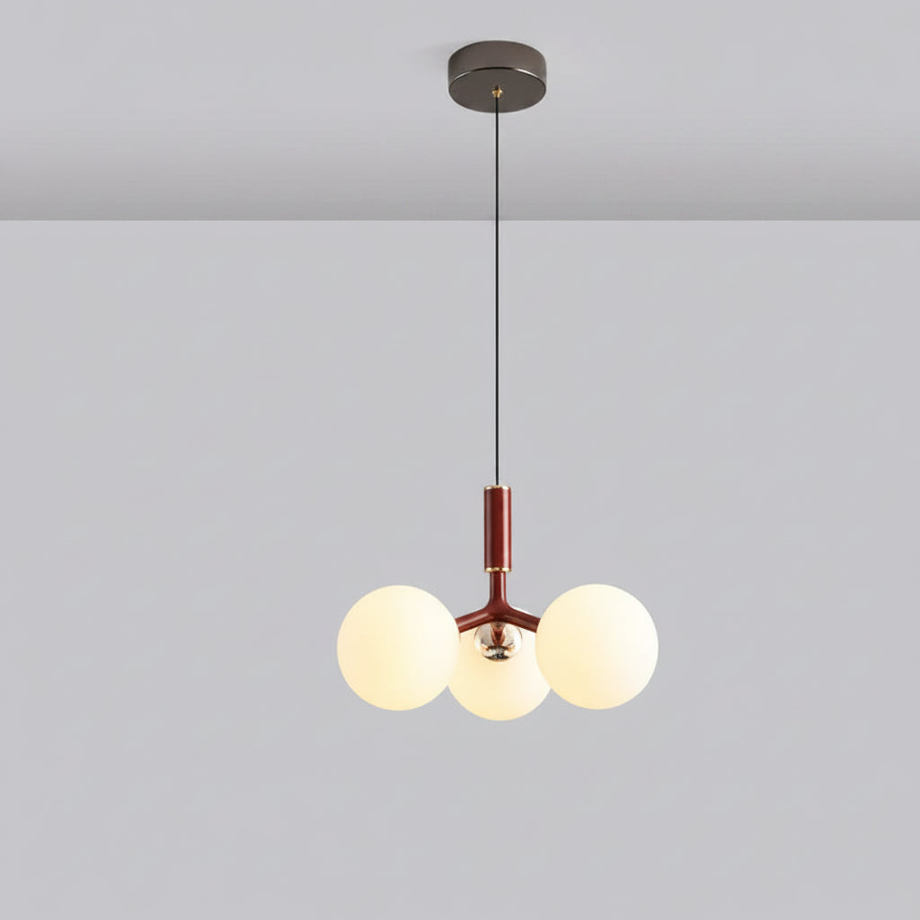 Globe pendant light with three white glass spheres and red central stem, black canopy