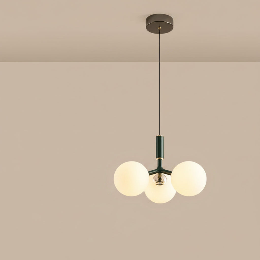 Globe pendant light with three white glass spheres and green central stem, black canopy