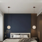 Two round travertine disc pendant lights on cords, warm downward light