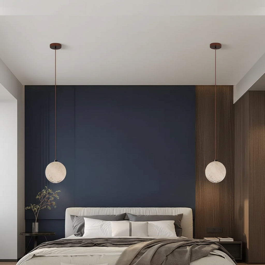Two round travertine disc pendant lights on cords, warm downward light
