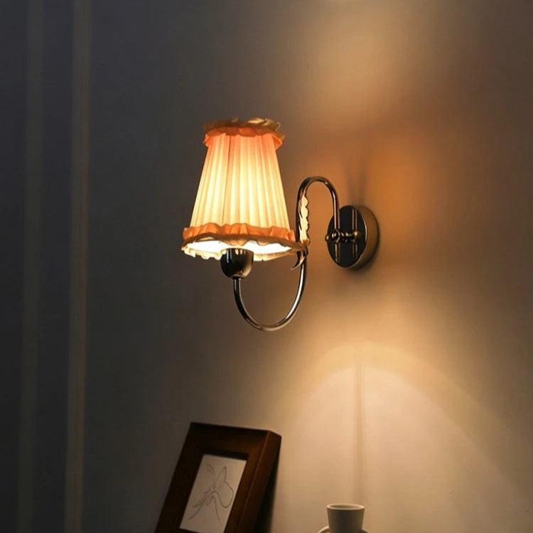 Wall light with lit ruffled fabric shade on a wall