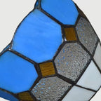 Close-up of blue stained-glass shade panels with black metal framing