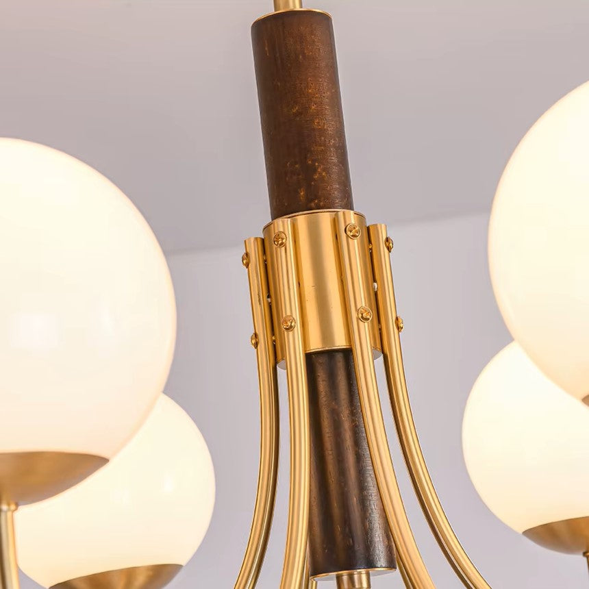 Close-up of globe chandelier dark brown stem and gold metal arms with round bulb shades