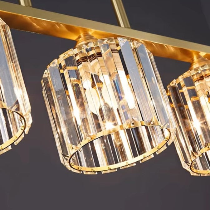 Close-up of gold chandelier hardware with clear faceted cylindrical glass shades