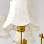 Close-up of cream scalloped fabric lampshade with gold socket and mounting