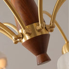 Close-up of chandelier center: brown wooden-like column with gold curved arms and sockets.