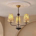 Multi-arm chandelier with floral conical shades and an illuminated ceiling canopy