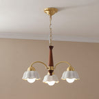 Multi-arm chandelier with gold arms, brown center stem, and three white scalloped shades.