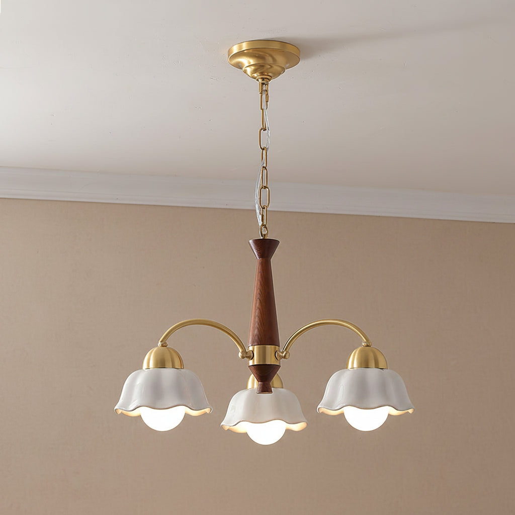 Multi-arm chandelier with gold arms, brown center stem, and three white scalloped shades.