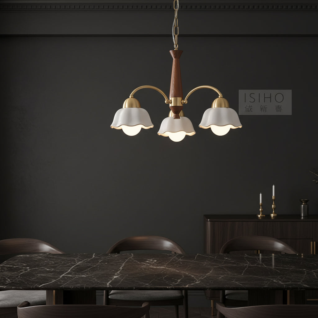 Scandinavian-style chandelier with gold arms, brown column, and five white scalloped shades.