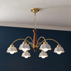 Ceiling-hung chandelier with gold top, brown center column, and five white scalloped shades.