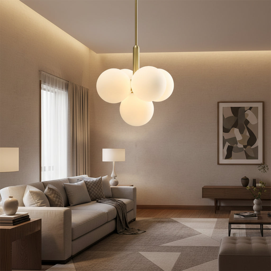 Gold hanging chandelier with frosted white glass bubble globes over living room seating