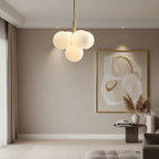 Gold and frosted white bubble globe hanging chandelier centered in a living room