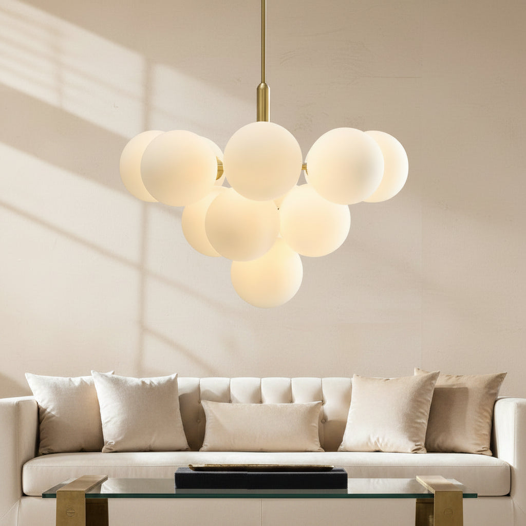 Brushed gold bubble chandelier with frosted white glass globes above a sofa