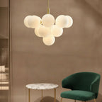 Frosted white bubble globe chandelier with brushed gold stem and canopy above seating